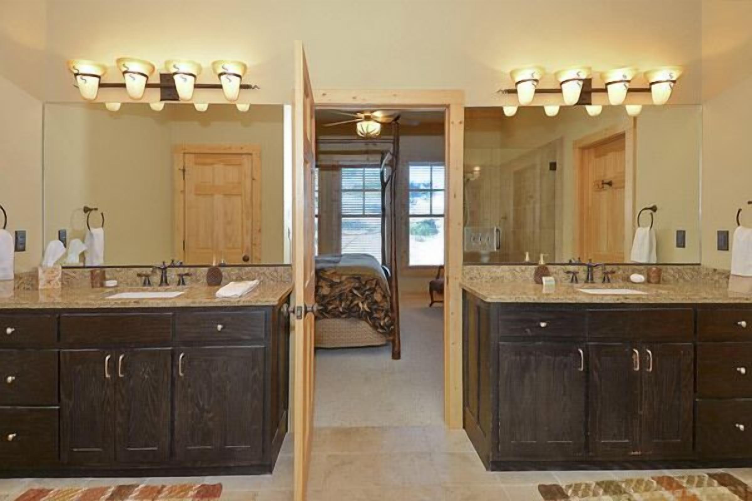 A bathroom with two sinks, dark wood cabinets, and a mirror.