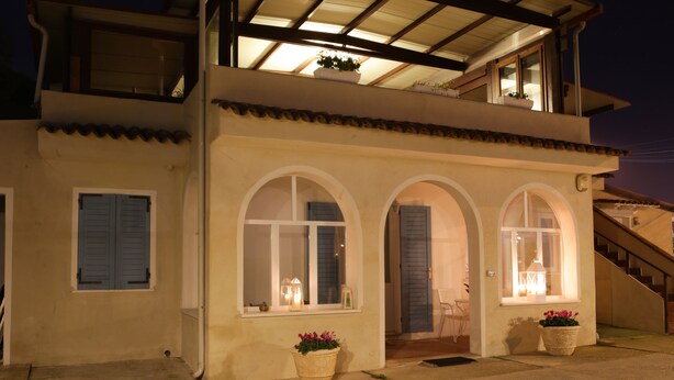 Un edificio de dos pisos con ventanas arqueadas y un balcón.