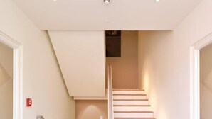 Een moderne trap met een minimalistisch ontwerp, witte wanden en een houten vloer.