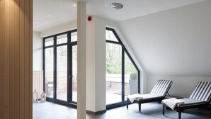 Een modern interieur met een hoge plafon, grote ramen en een schuin dak.