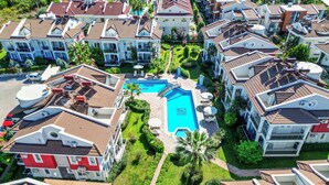 A residential area with multiple houses, a swimming pool, and lush greenery. - Sea Heaven Legend Apartments (Fethiye)