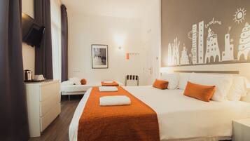 Une chambre d’hôtel comprenant un lit, un bureau, une chaise, un téléviseur et un mur orné d’un dessin représentant un paysage urbain.