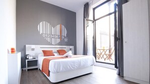 A modern hotel room with a large bed, a nightstand, a wall with a heart-shaped design, and a balcony with a view. - Hostal Live Barcelona (Barcelona)