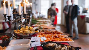 A buffet table with various dishes and a candelabra with lit candles.