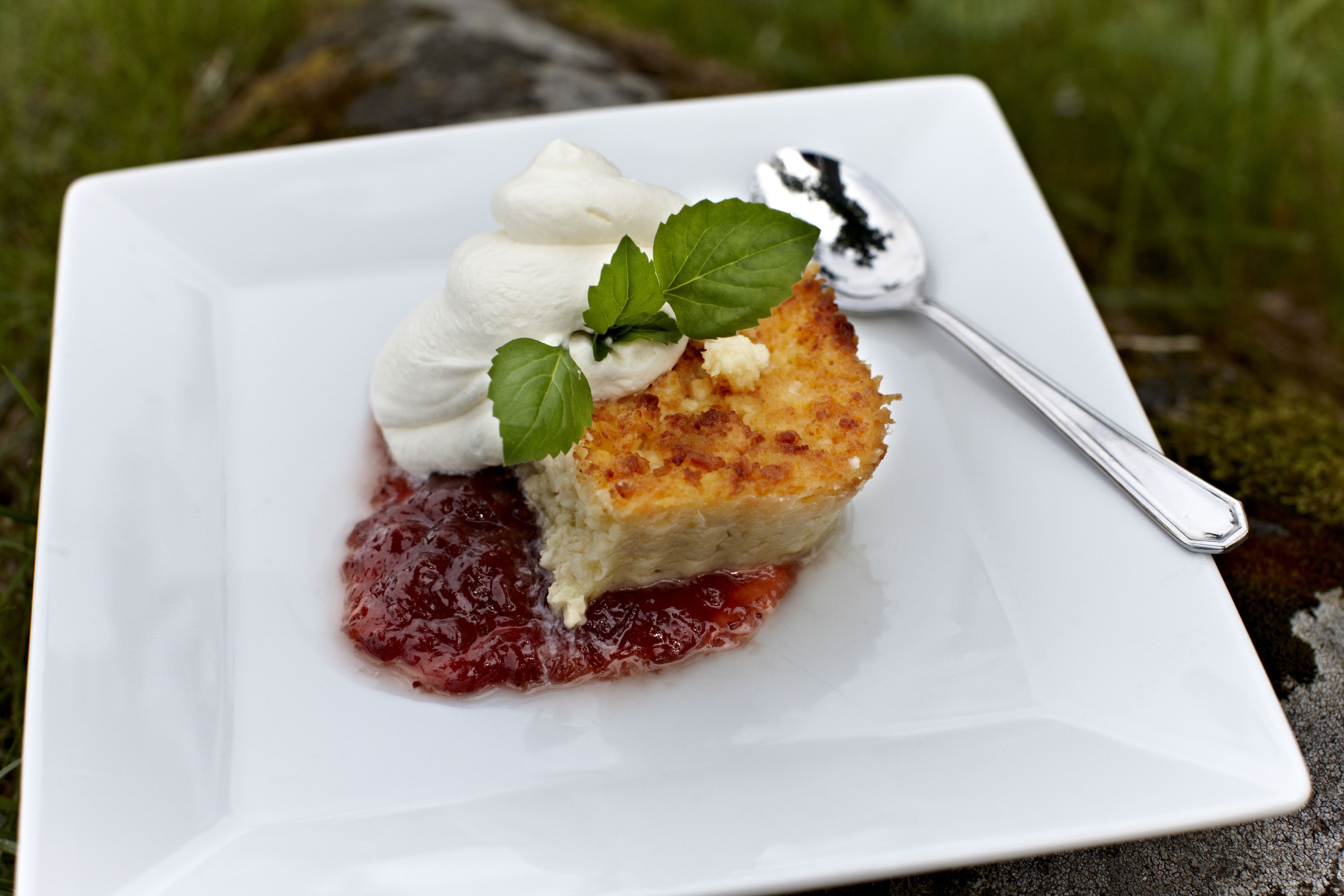 A dessert on a white plate with a spoon.