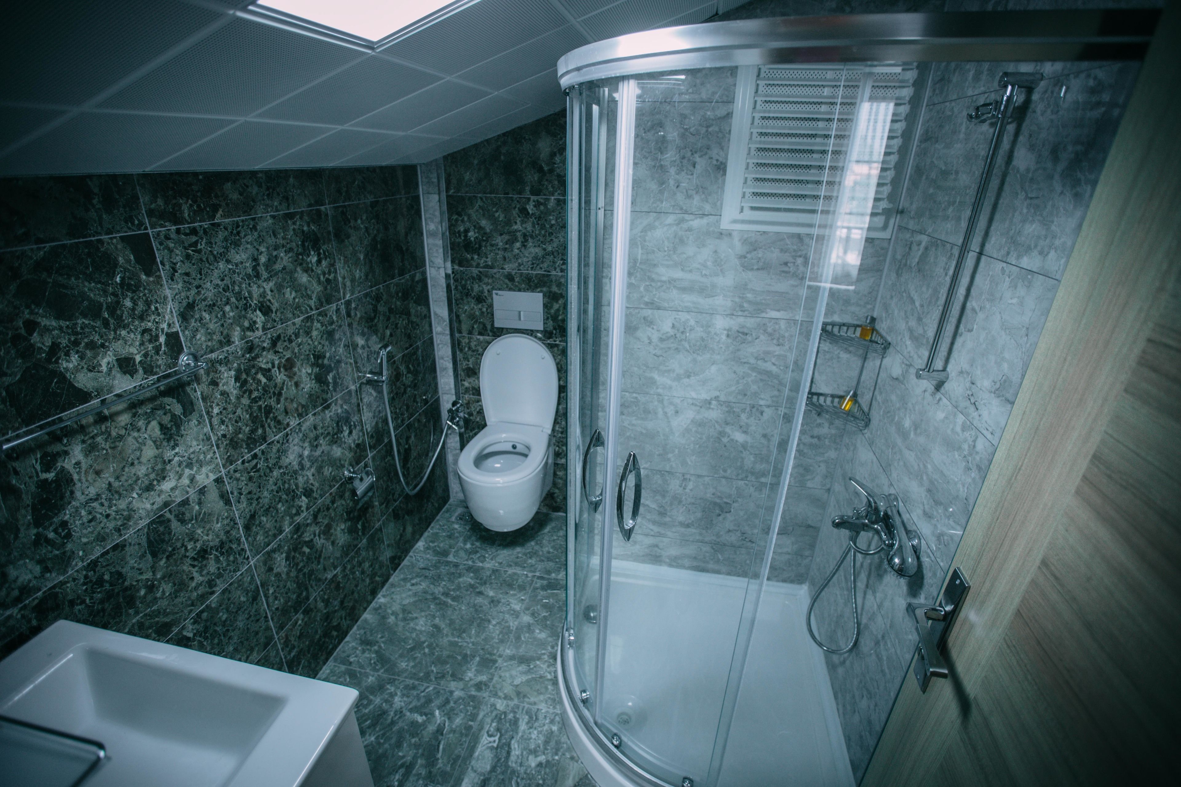Un baño moderno con ducha acristalada, inodoro blanco y bañera.