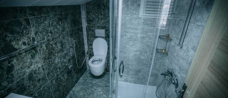 Un baño moderno con ducha acristalada, inodoro blanco y bañera.