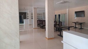 Um hall amplo com balcão de recepção, área de estar e parede estampada.