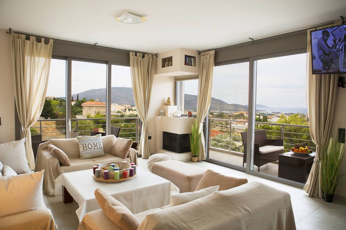 A spacious balcony with a sofa, a table with a fruit bowl, and a TV.