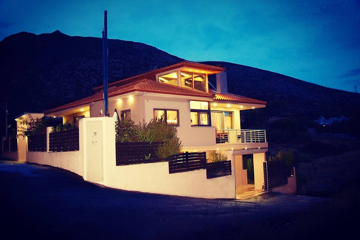 A modern house with a balcony, large windows, and a garage.
