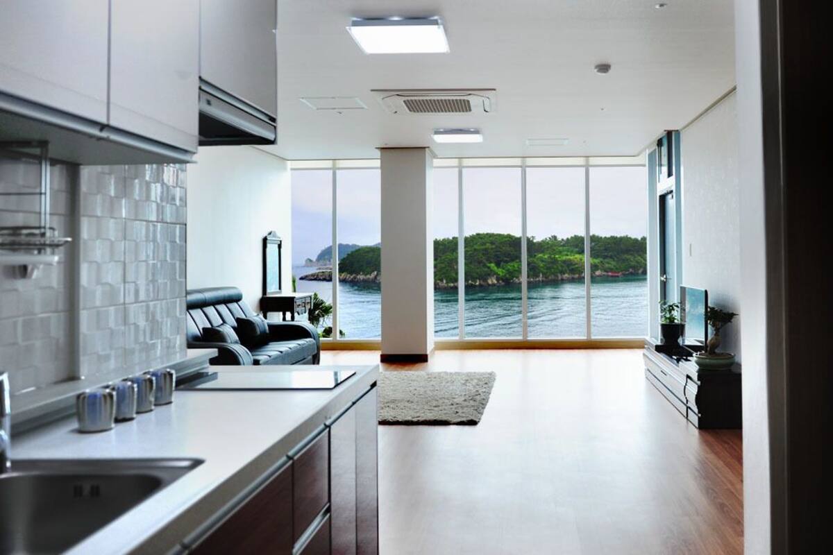 A modern kitchen with a large window overlooking a body of water.