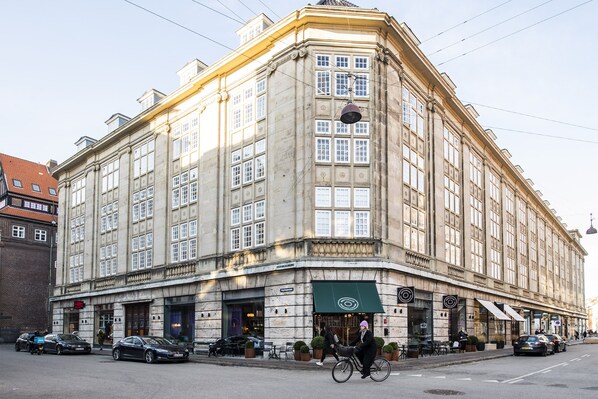 Ein historisches Gebäude mit großen Fenstern und einem Eingang im Winkel.