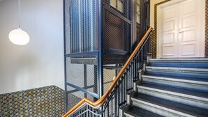 Un escalier avec une rampe en métal et une porte blanche en haut.