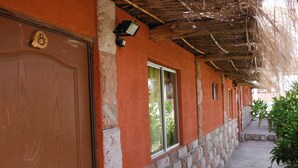 Un pasillo con una puerta de madera, una ventana y una pared de piedra.