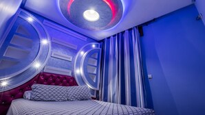 A bedroom with a circular ceiling light, a tufted headboard, and striped curtains. - Dar Saida Hora (Chefchaouen)