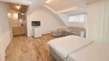 Suite Studio, 1 grand lit et 1 canapé-lit, cuisine, vue ville | Coin séjour | Télévision LCD