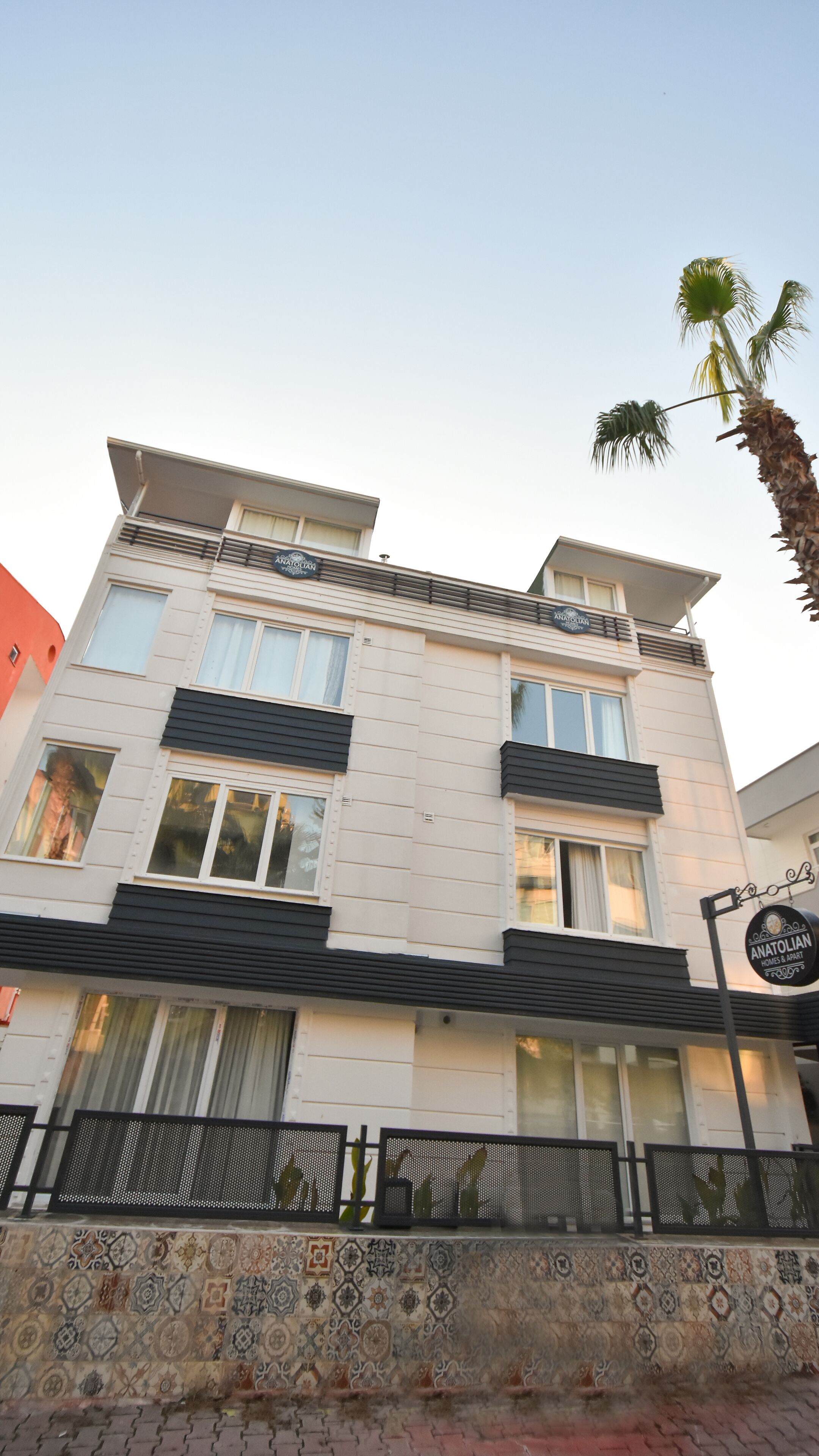 Een modern gebouw met een bord waarop 'Anatolian Homes & Apartments' staat.