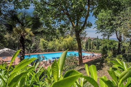 Una piscina al aire libre de temporada, sombrillas
