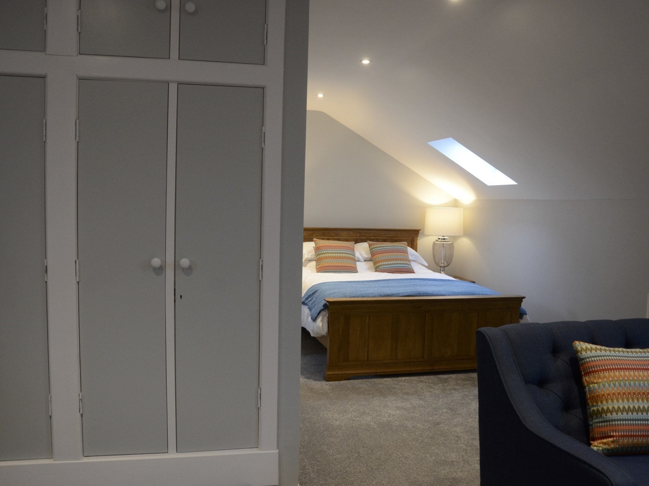 Une chambre à coucher avec un lit, une chaise et une armoire.