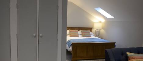 Une chambre à coucher avec un lit, une chaise et une armoire.