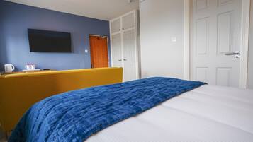 Um quarto com uma cama, uma escrivaninha e um guarda-roupa.