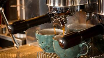 A coffee machine dispensing espresso into two ceramic cups.
