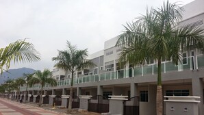 Un edificio moderno con varios balcones, palmeras y un paseo pavimentado.