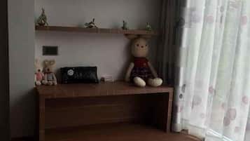 Una sala de estar con un banco de madera, un sillón cómodo y un televisor montado.