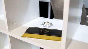Ein weißes Regalsystem mit einem schwarz-goldenen Buch auf einer der Regalböden.
