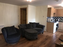 Apartamento Deluxe, 2 habitaciones | Zona de estar | Una televisión de pantalla plana