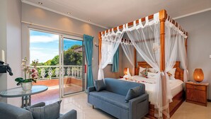 Une chambre à coucher avec un lit à baldaquin, un canapé, une table de chevet et une vue sur l’extérieur.