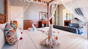 Une chambre d’hôtel avec un lit, un canapé, un bureau et un miroir.