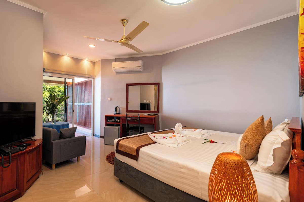 Une chambre d’hôtel avec un lit, une télévision, un bureau et une chaise.