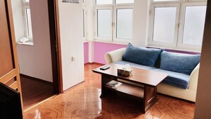 Une pièce avec un canapé, une table basse et une fenêtre.