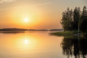 A calm lake at sunset with a forested shoreline. - Hapimag Resort Punkaharju (Savonlinna)