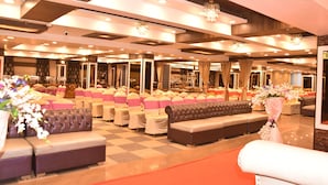 A spacious hall with multiple seating areas, including sofas and chairs, arranged for an event. - The Grand Empire A Boutique Hotel (Patna)