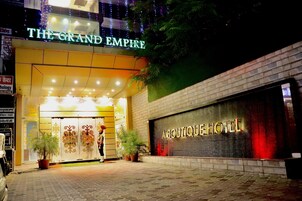 La entrada del hotel The Grand Empire, con un cartel llamativo y un letrero que indica Hotel Boutique.