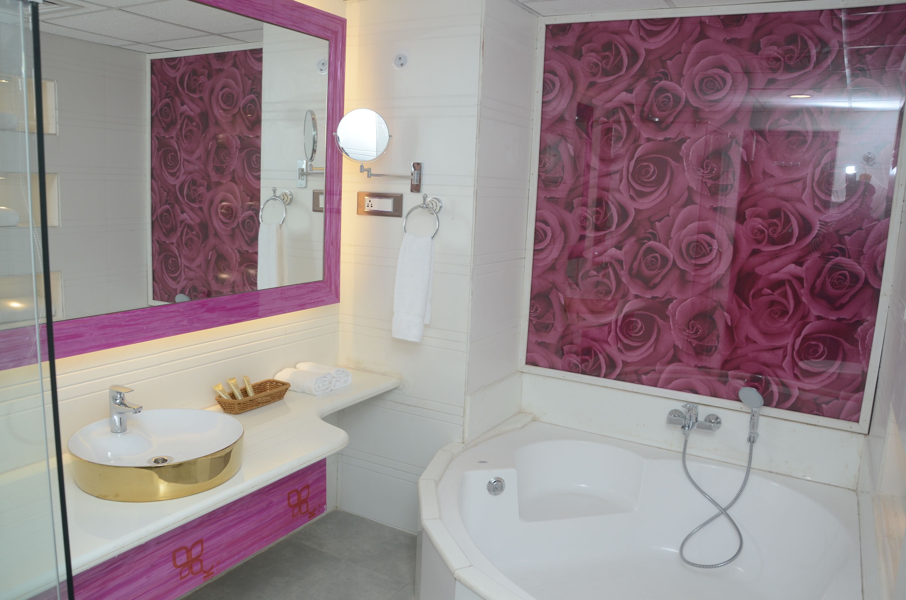 A bathroom with a white sink, a mirror, a white bathtub, and a shower.