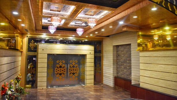 A lobby with a wooden ceiling, chandeliers, and a reception desk. - The Grand Empire A Boutique Hotel (Patna)