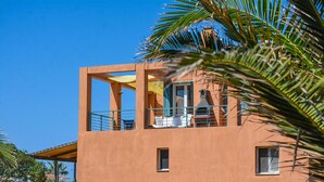 A modern building with a balcony, a small window, and a door. - Alekos Beach Houses-Infinity (Kefalonia)