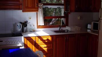 Apartamento, 2 quartos | Cozinha privada | Geladeira, micro-ondas, fogão, cooktop