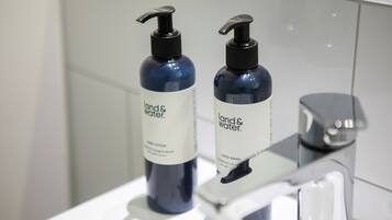 Two bottles of hand lotion and a faucet on a bathroom sink.