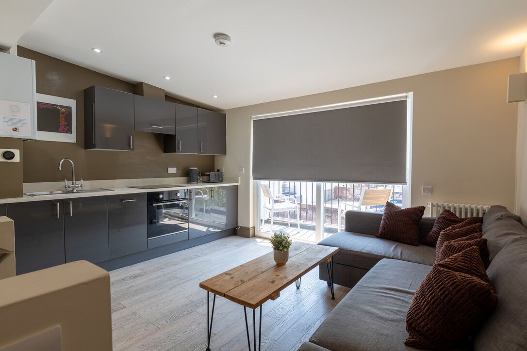 A modern apartment with a kitchen, dining area, and living room.