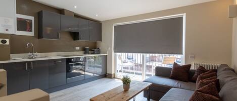 A modern apartment with a kitchen, dining area, and living room.