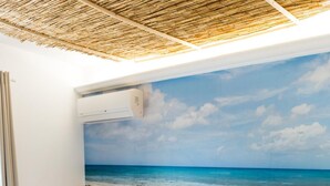 A bedroom with a beach mural, a wooden bed frame, and a nightstand with a lantern. - B&B Villa Saraceni (Vasto)