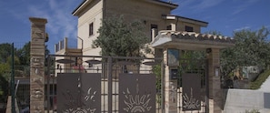 A two-story house with a gated entrance, a balcony, and a pergola. - B&B Villa Saraceni (Vasto)