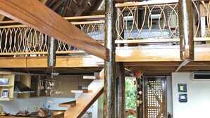 A wooden interior with a staircase, a ceiling fan, and a kitchen area with appliances. - Waimea Luxury Houses - Adults Only (Puerto Galera)