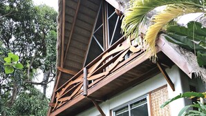 A two-story house with a thatched roof, large windows, and a wooden balcony. - Waimea Luxury Houses - Adults Only (Puerto Galera)