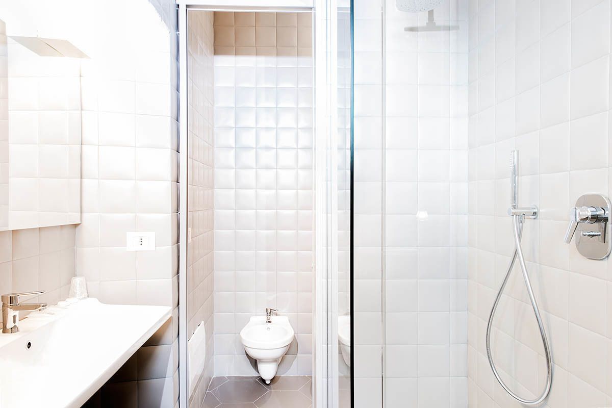 Ein modernes Badezimmer mit einem weißen Waschbecken, einem Bidet und einer Dusche.