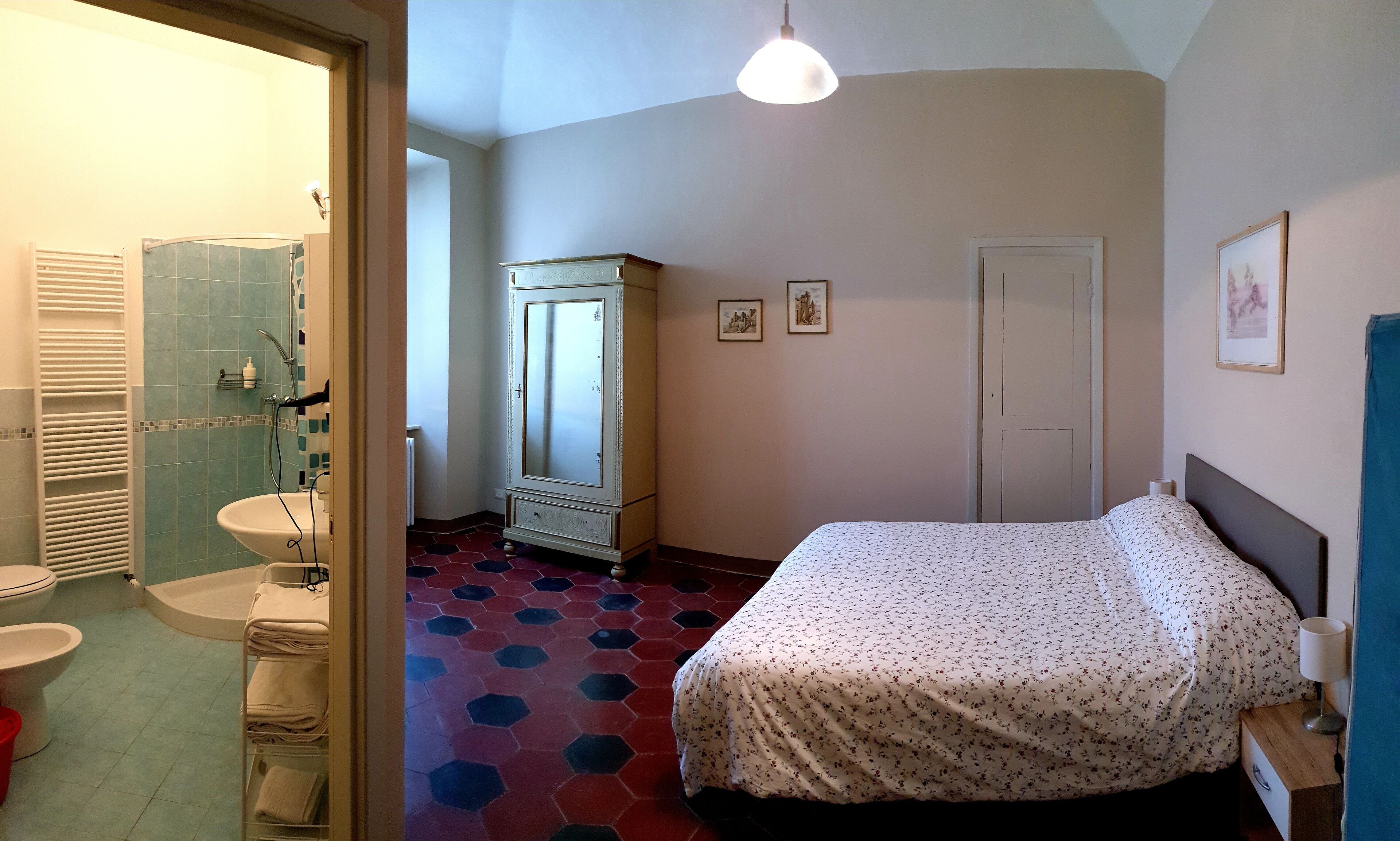 A bedroom with a bed, a dresser, a mirror, and a door.